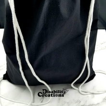 Load image into Gallery viewer, The back of the drawstring bag. The bag is black with white string handles.
